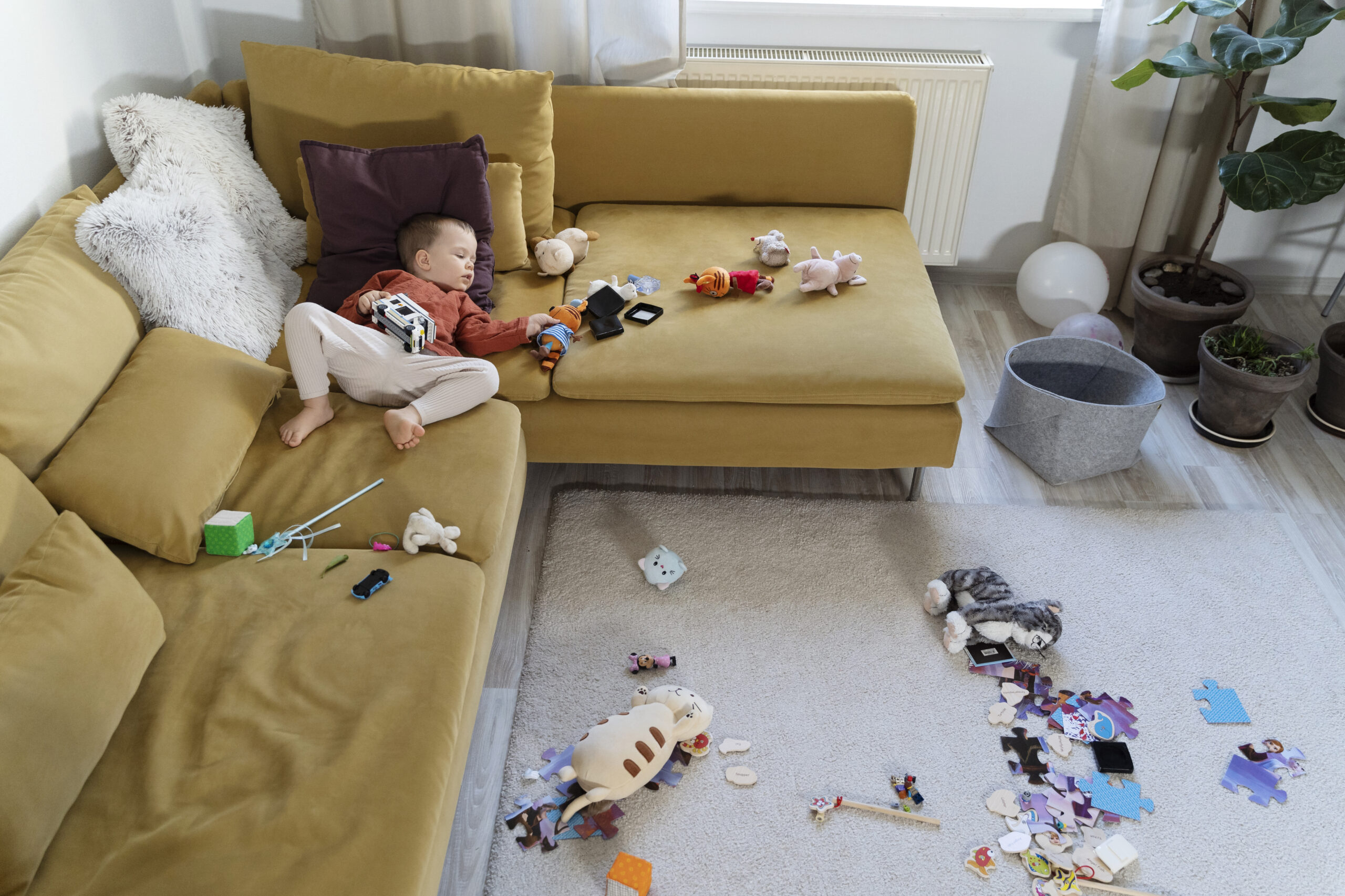 full shot kid laying couch with toys 300x200 1 scaled