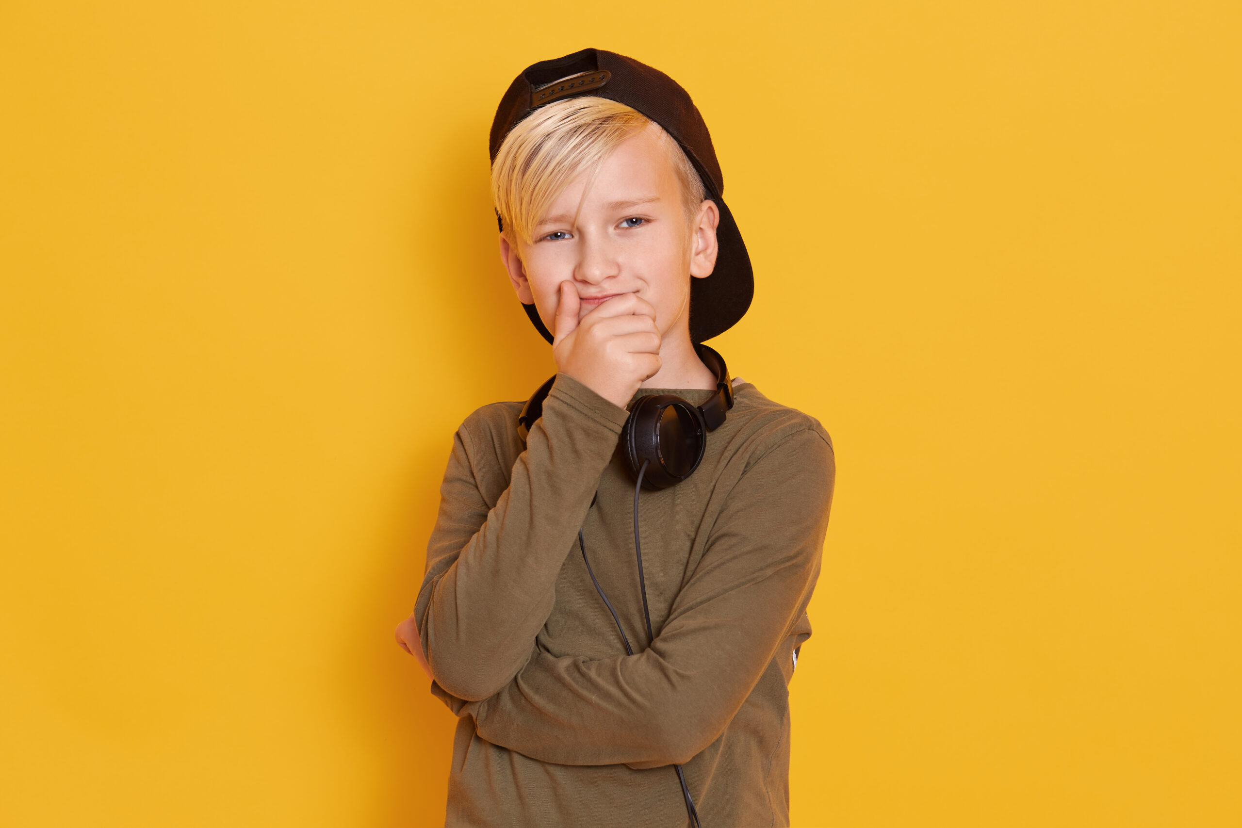 portrait little boy wearing black cap cute guy posing isolated yellow male kid covering mouth with hands 300x200 1